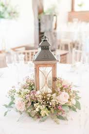 Centre De Table Mariage Rustique Avec Lanterne Facon Bois Entouree De Fleurs Centre De Table Mariage Table Mariage Table Mariage Romantique
