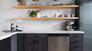 White kitchen cabinets brighten up this kitchen, providing contrast to dark wood flooring and deep blue walls. The Best Types Of Paint For Kitchen Cabinets
