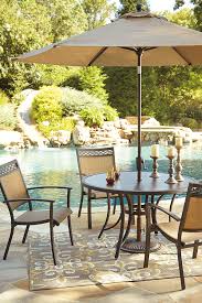 The Best Part Of Dining Out Includes The Carmadelia Round Dining Table The Glass Tabletop Hand Painted To Re Round Patio Table Round Dining Table Patio Table