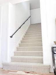 Below, a black handrail is sturdy and thick, while thin metallic supports add visual interest. Modern Black Handrail White Lane Decor