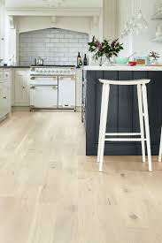 On Trend White And Pale Blonde Woods Give Any Room A Lighter Brighter Feel But They Can Be Practical Wood Floor Kitchen Oak Floor Kitchen Rustic Wood Floors
