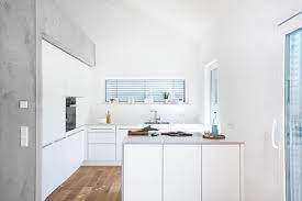 weisse kuche mit integrierter speisekammer und betonelementen edelstahlgriffe helle arbeitsplatte und dunstabzug nach kuchen design weisse kuche wohnung kuche