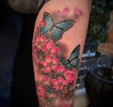 A custom tattoo design of the word hope made with cherry blossom flowers, breast cancer awareness ribbon, butterfly and winged angel heart. Butterfly And Cherry Blossom Tattoo By Christina Ramos At Memoir Tattoo Cherry Blossom Tattoo Blossom Tattoo Tattoos