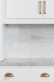 A marble backsplash adds drama to this minimalist kitchen designed by london architects drdh. White Marble Kitchen Backsplash With Marble Tiles Brass Grout Via Artisan Signature Homes Kitchen Marble Kitchen Tiles Backsplash The Tile Shop