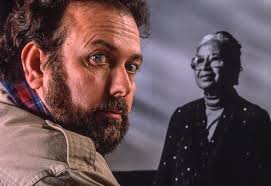 Smith Family Bookstore employee Michelle Loew is dwarfed by a stack of  books in the entry way of the downtown bookstore as she and other employees  work to move books from the