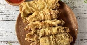 Gambar sepiring sawi goreng yang disajikan hangat dengan bawang goreng dan irisan cabai merah