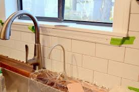 The easiest way to care for windows and trim is not to cut the tile to fit exactly, but to cut chunks out of the trim to slip the tile underneath (much like you would cut under door frames with a jamb saw). Kitchen Details The Window Ledge Ugly Duckling House
