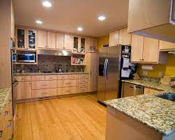 Natural maple kitchen cabinets with sleek lines paired with an impressive stainless range hood create an inspired contemporary look. Natural Maple Kitchen Country Cabinets