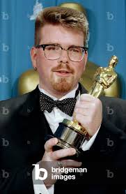 Image of Winner for Best Original Screenplay, Christopher McQuarrie, holds  up his