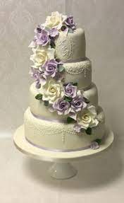 Esme 4 Tier With Piped Lace And Monogram Detail And Sugar Flower Cascade In Shades Of Lilac And Iv Themed Wedding Cakes Wedding Cakes Lilac Lace Wedding Cake