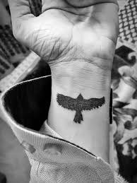 Forearm Bird Tattoos For Guys Bird In Flight Tattooed In Black On The Wrist Of A Man With A Long Sleeved Shirt Forearm Tattoos In 2020 Small Tattoos For Guys Tattoo Designs Men Tattoos