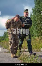 United States Army Spc. Daniel Edwards, a New Caney, Texas native assigned  to Dog Company, 1st Battalion, 503rd Infantry Regiment, 173rd Airborne  Brigade, role-playing a notional oppositional force character, is lead to a  holding area by Lithuanian ...
