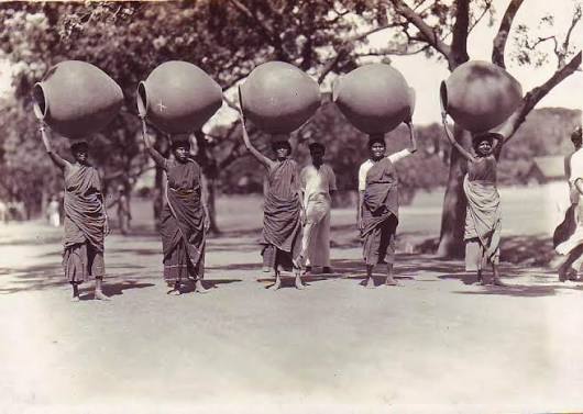 Old picture of Madras women carrying cow dung.