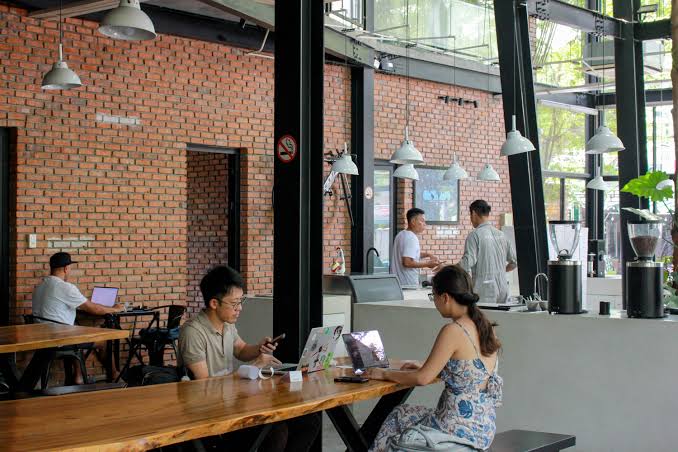 People working from a laptop-friendly cafe