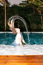 Young Woman Flicks Hair With Water In The Air While Wearing All Her Clothes In The Pool Young Woman Flicks Hair With Wate Flicks Hair Pool Picture Pool Photos