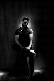 Handsome Man Sitting In Dark Room By Mosuno For Stocksy United Portrait Photography Men Poses For Men Photography Boy Senior Portraits