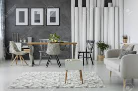 Ideally, the rug should be both functional and fashionable; White Carpet In Front Of A Beige Sofa In Monochromatic Living Room With Wooden Dining Table And Chairs Stock Photo Picture And Royalty Free Image Image 93881379