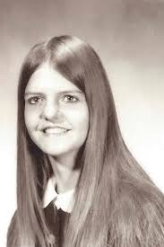 What is the age of the photo in the 1973 postcard?