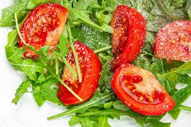 plate of salad tomato, arugula, grated cheese, olive oil healthy meal food  snack on the table copy space food background rustic top view keto or paleo  diet veggie vegan or vegetarian food