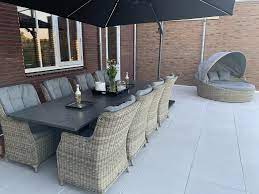 lange granieten tuintafel met luxe tuinstoelen zweefparasol en beachhouse tuintafels tuinstoelen tuin meubelen
