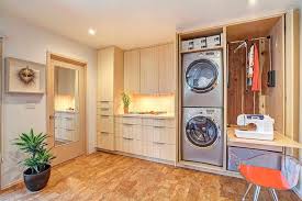 Une buanderie avec une machine à laver et sèche linge en superposition, le tout caché derrière une jolie porte coulissante rustique. Meuble Pour Machine A Laver Esthetique Et Fonctionnel En 18 Idees