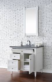 Blue mini brick backlash tiles above a gray bath vanity with gray shaker cabinets and polished nickel pulls topped with black granite countertops. James Martin Brittany Single 36 Inch Transitional Bathroom Vanity Bright White