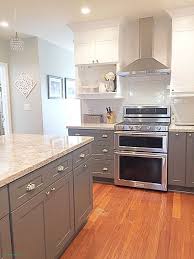 A stainless steel range and oven is flanked by classic white cabinets with nickel hardware. What Color Laminate Flooring With Oak Cabinets Laminate Flooring