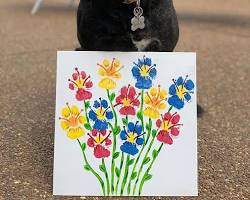 person creating a paw print art with their dogの画像