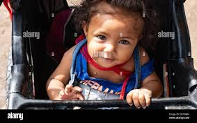 Reynosa, Mexico. 15th July, 2021. a family poses for the camera at the edge  of the plaza next to a small kitchen that caters for the needs of the  migrants. Credit: Lexie