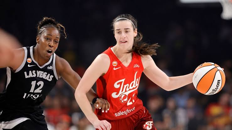 Caitlin Clark driving past a defender during a WNBA game, do AI tạo