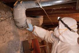 Technician sealing crawlspace ducts with spray foam for insulation and moisture protection.
