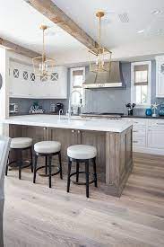 Farmhouse Kitchen With Exposed Reclaimed Beams Wide Plank Hardwood Flooring White Oak Kitchen Isl Coastal Kitchen Design Coastal Kitchen Herringbone Backsplash