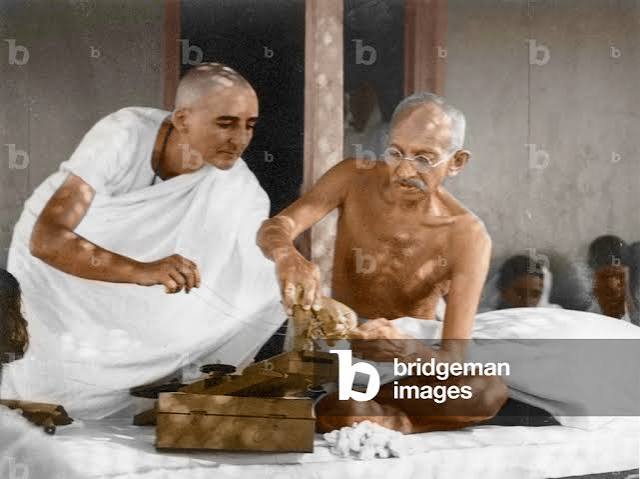 Image of Mahatma Gandhi assisted by Mirabehn, repairing spinning wheel, Wardha, 1936