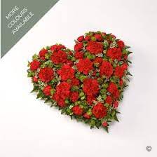 Heart shaped sympathy flowers or funeral flowers near a tree, big red roses. Carnation Heart Buy Online Or Call 023 8089 1085
