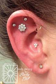 triple flat of the ear forward helix loop and conch piercing with neometal gold trinity top unique ear piercings cute ear piercings cool ear piercings