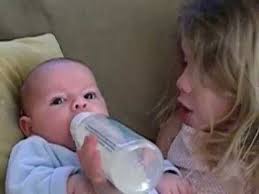 big sister feeding little brother