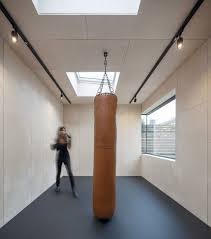 Salle De Gym Avec Sac De Frappe Carrelage Clair Et Plafond Avec Puits De Lumiere Salle De Sport Maison Salle De Sport Studio De Jardin