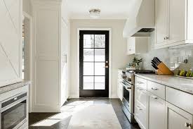 A black rug sits atop slate herringbone entry floor tiles and in front of a limed oak foyer table styled and located under a nautical art piece it by a nickel picture light. Black Herringbone Kitchen Floor Tiles Design Ideas