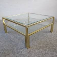Unusual vintage coffee table with two tiers of glass tabletops, and a brass base. Two Tiers Brass Glass Coffee Table By Pierre Vandel 1970s 91898