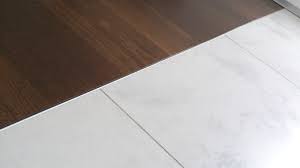 Hellem marmor und buntem mosaik in eine fläche aus dunklem parkett verlegen und den übergang von parkett zu fliesen meistern. Fuge3 Whitecube Home