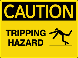 The sign is intended to alert emergency responders and visitors of potential hazards and precautions for entry. Caution Tripping Hazard Wall Sign