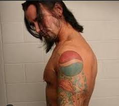 Who is the bald and tattooed man?