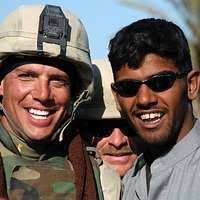 Steelworker 3rd Class Brian Laferriere, of Naval Mobile Construction  Battalion (NMCB) 7, photographs Riarok Elementary School students as they  enjoy their new playground, built by battalion personnel.