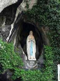 Crowd of pilgrims waiting to enter grotte de massebielle cave in notre dame de lourdes sancutuary, where the holy mary apparition is said to have happened. La Historia De La Virgen De Lourdes