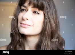 Giovane donna close-up tre quarti ritratto. Caucasian marrone con capelli  lunghi e bangs. Espressione serena, guardando verso l'alto. Le fossette  Foto stock