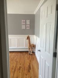 Welcoming white and blue boy's nursery features a window covered in a white roman shade lined with blue trim. Nursery Entry Way Grey Walls Wainscotting Giraffe White Wainscoting Wainscoting Nursery Wainscoting Bedroom