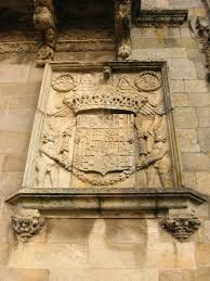 In the 16th century the catholic monarchs constituted the foundation of the royal hospital and to house it they commissioned the building now occupied by the hostal dos reis católicos, converted in 1954 into a luxury hotel. Escudo Hostal De Los Reyes Catolicos Santiago Coat Of Arms Heraldry Arms