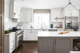 White Shaker Cabinets Mixed With A Gray Island Brings A Two Toned Design To A Trans Shaker Style Kitchen Cabinets Kitchen Island Cabinets White Shaker Cabinets