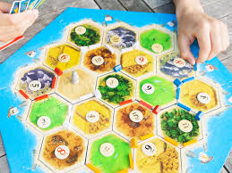 You may play development cards at any time during your turn, also in the middle of your trade phase. Catan Review Your New Game Night Favorite