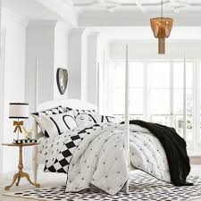 Black walls contrast starkly with a crisp white ceiling and white bedding. Tips For Decorating With Black White Featuring Our New Emily Meritt Designs Pottery Barn